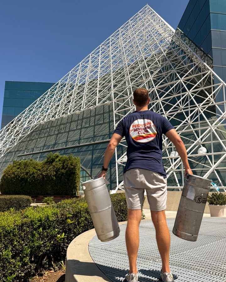 A Perpetual founder carrying two California Roasting Collective cold brew kegs into an office building in Miramar